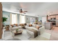 Open living room featuring a large sectional sofa and a view into the kitchen at 377 Yellow Finch Ln, Henderson, NV 89012