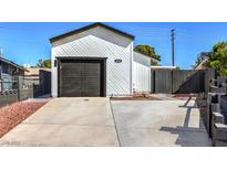 White house with dark gray garage door and landscaping at 6804 Atrium Ave, Las Vegas, NV 89108