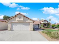 Charming single story home with a two car garage and colorful flower beds at 2829 Forrest Duke Ct, Las Vegas, NV 89108