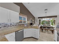 Bright kitchen with granite countertops and stainless steel dishwasher overlooking dining area at 2829 Forrest Duke Ct, Las Vegas, NV 89108