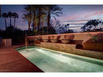 Inviting pool area featuring custom water feature wall and lush palm trees at 36 Avenida Fiori, Henderson, NV 89011