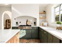 Bright kitchen features a stainless steel range, olive cabinets, and white marble countertops at 2031 Mondo Ct, Las Vegas, NV 89123