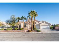 Charming single-story home featuring desert landscaping, including mature palm trees, and a two-car garage at 368 E Rush Ave, Las Vegas, NV 89183