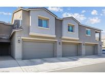Three-unit townhome building with attached garages and a modern design at 4465 Shimmering Skies St # 1177, North Las Vegas, NV 89031