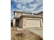 Tan two story home featuring an attached two car garage and tile roof at 5834 Autumn Harvest Ave, Las Vegas, NV 89142