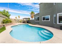 Beautiful pool with baja step, concrete surround, and outdoor kitchen for relaxing and entertaining at 6112 Browning Way, Las Vegas, NV 89130