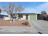 Single story home with green garage door and mature tree in front yard at 6214 Gunderson Blvd, Las Vegas, NV 89103