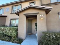 Inviting exterior featuring a two-story tan building with landscaping at 1571 Plaza Centre Dr # 102, Las Vegas, NV 89135