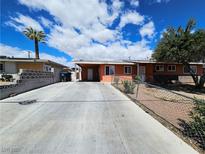 Ranch style home with driveway, landscaped yard, and chain link fence at 2208 W Washington Ave, Las Vegas, NV 89106