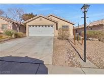 Single-story house with a white garage door and landscaped yard at 9012 Medicine Wheel Ave, Las Vegas, NV 89143