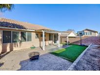 Backyard with covered patio, artificial turf, fire pit, and basketball hoop at 9613 Sterling Ridge Ave, Las Vegas, NV 89129