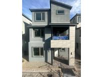 Modern two-story home with gray stucco exterior and a balcony above the front door at 1433 Nocturnal Flight St, Las Vegas, NV 89138