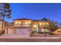 Two-story house with balcony, landscaped yard, and two-car garage at 9304 Angelfish Dr, Las Vegas, NV 89117