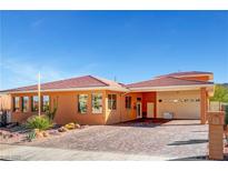 One-story home with brick exterior, paver driveway, and desert landscaping at 943 Woodacre Dr, Boulder City, NV 89005