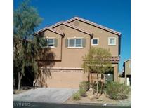 Two-story house with tan siding, a two-car garage, and landscaping at 10371 Calypso Cave St, Las Vegas, NV 89141