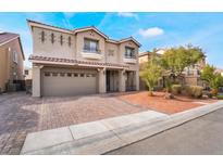 Two-story home featuring a brick driveway, a two-car garage, and well-maintained landscaping at 10529 Parthenon St, Las Vegas, NV 89183