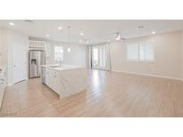 Open concept kitchen with island, stainless steel appliances, and white cabinetry at 10718 Glowing Dawn Ave, Las Vegas, NV 89135