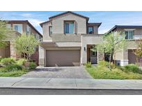 Two-story home featuring a two-car garage, neutral color palette, manicured lawn, and complementary landscaping at 43 Strada Loreto, Henderson, NV 89011