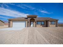 Charming single-story home featuring a two-car garage and neutral color palette at 5821 Genoa Ave, Pahrump, NV 89060