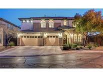 Two-story house with three-car garage, stone accents, and landscaping at 8593 Garden Valley Ct, Las Vegas, NV 89178