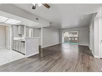 Open living room with wood-look floors and access to the kitchen and patio at 1900 High Valley Ct # 104, Las Vegas, NV 89128