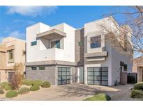 Modern two-story home with gray stone and white siding, two-car garage, and landscaped front yard at 232 Errogie St, Henderson, NV 89012