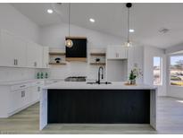 Modern kitchen boasts white cabinets, a large island, and a sleek range hood at 2905 Legend Dr, Las Vegas, NV 89134