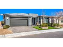 Single-story home with gray garage door and landscaped yard at 4720 E Cactus Canyon Dr, Pahrump, NV 89061