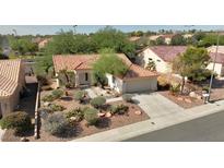 Single-story house with tile roof, landscaped yard, and two-car garage at 10013 Cresent Creek Dr, Las Vegas, NV 89134