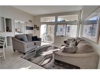 Bright living room with two sofas, large windows, and a view to a patio at 3125 N Buffalo Dr # 2120, Las Vegas, NV 89128