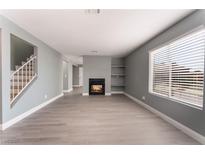 Bright living room with a fireplace, built-in shelves, and wood-look floors at 3802 Terrazzo Ave, Las Vegas, NV 89115