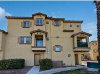 Tan three-story townhome with multiple balconies and landscaping at 5915 Nuevo Leon St # 7, North Las Vegas, NV 89031