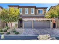 Two-story house with gray siding, stone accents, and a three-car garage at 87 Newton Ridge Way, Las Vegas, NV 89183