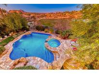 Luxury pool and spa with stonework, offering scenic mountain views at 38 Benevolo Dr, Henderson, NV 89011