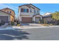 Two-story house with a brown door and attached garage, landscaping, and a paved driveway at 6233 Andover Wood Rd, Las Vegas, NV 89113