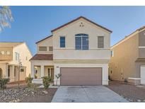 Two-story house with beige exterior, taupe garage door, and landscaping at 7808 License St, Las Vegas, NV 89131