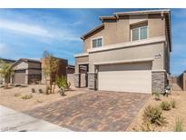 Two-story house with beige exterior, stone accents, and a paved driveway at 230 Palisade Falls Ave, Henderson, NV 89015