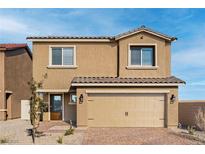 Two-story house with tan exterior, two-car garage, and landscaped front yard at 4253 Gold Desert St, North Las Vegas, NV 89032