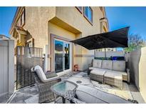 Cozy outdoor patio featuring stylish seating and a shade umbrella for comfortable relaxation at 4710 Frasers Owl Ave # 103, North Las Vegas, NV 89084