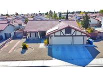 Single-story house with red tile roof, two-car garage, and landscaped yard at 8517 Soneto Ln, Las Vegas, NV 89117