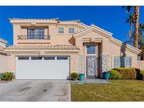 Two-story house with beige exterior, white garage door, and landscaped lawn at 8986 Lillyhammer Ct, Las Vegas, NV 89147