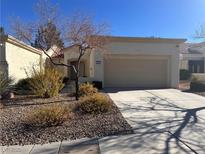 Tan two-car garage, desert landscaping, and walkway to entry at 2124 Spring Water Dr, Las Vegas, NV 89134