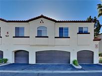 Townhouse exterior with three-car garage and Spanish-style architecture at 2975 Bluegrass Ln # 422, Henderson, NV 89074