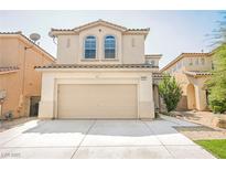 Two story house with beige exterior, two car garage, and landscaped yard at 4937 Caprock Canyon Ave, Las Vegas, NV 89139