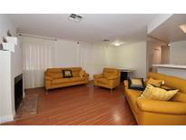 Bright living room with hardwood floors and mustard yellow sofas at 8600 W Charleston Blvd # 2101, Las Vegas, NV 89117