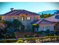 Luxury two-story home with a terracotta tile roof, fountain, and mountain views at 9513 Verlaine Ct, Las Vegas, NV 89145