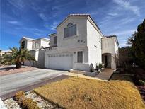 Charming two-story stucco home with a two-car garage, landscaped yard, and tile roof at 1808 Cedar Bluffs Way, Las Vegas, NV 89128