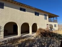 Two story home with covered patio, arched entryways, and a large yard at 4980 W Weddle Way, Moapa, NV 89025