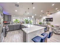 Modern kitchen with large island, stainless steel appliances, and gray cabinets at 7428 Radville Dr, Las Vegas, NV 89129