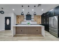 Modern kitchen with wood and black cabinets, large island, and stainless steel appliances at 160 Swale Ln, Las Vegas, NV 89144